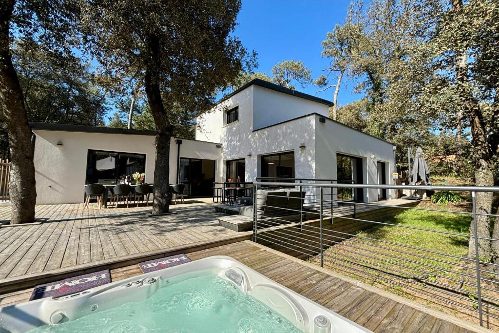 a house with a hot tub in the backyard at La villa des Dunes - Brétignolles sur mer in Brem-Sur-Mer