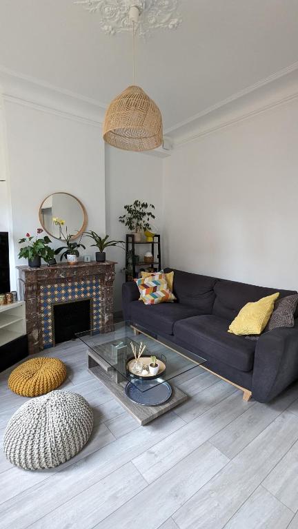 un salon avec un canapé bleu et une table en verre dans l'établissement Mon Jardin Secret Marseillais avec terrasse dans le quartier le plus cool du Monde, à Marseille