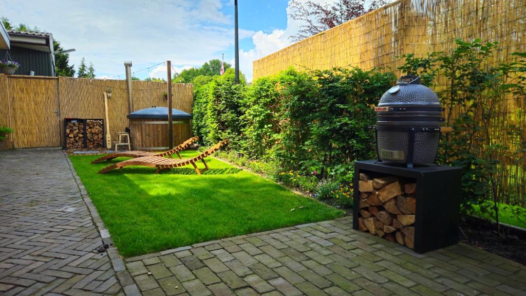 WeiteveenにあるLuxe Hottub Huisje Bij het Veen op de rand van het Bargerveen Drentheの庭に柵とベンチがある庭