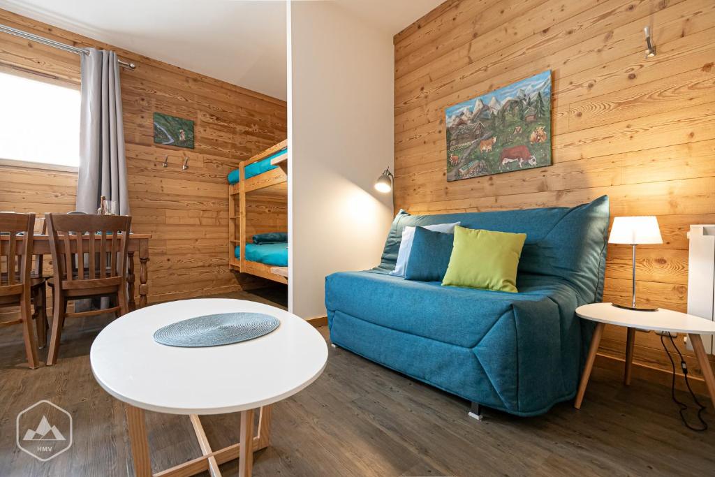 - un salon avec un canapé bleu et des lits superposés dans l'établissement Côté-Bourget 4 pers L'ORGERE proche La Norma Aussois, à Villarodin-Bourget