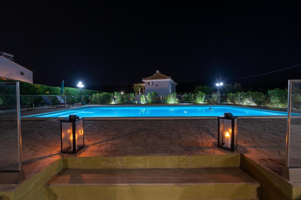 una piscina notturna con luci intorno di Spedion Villa a Gythio