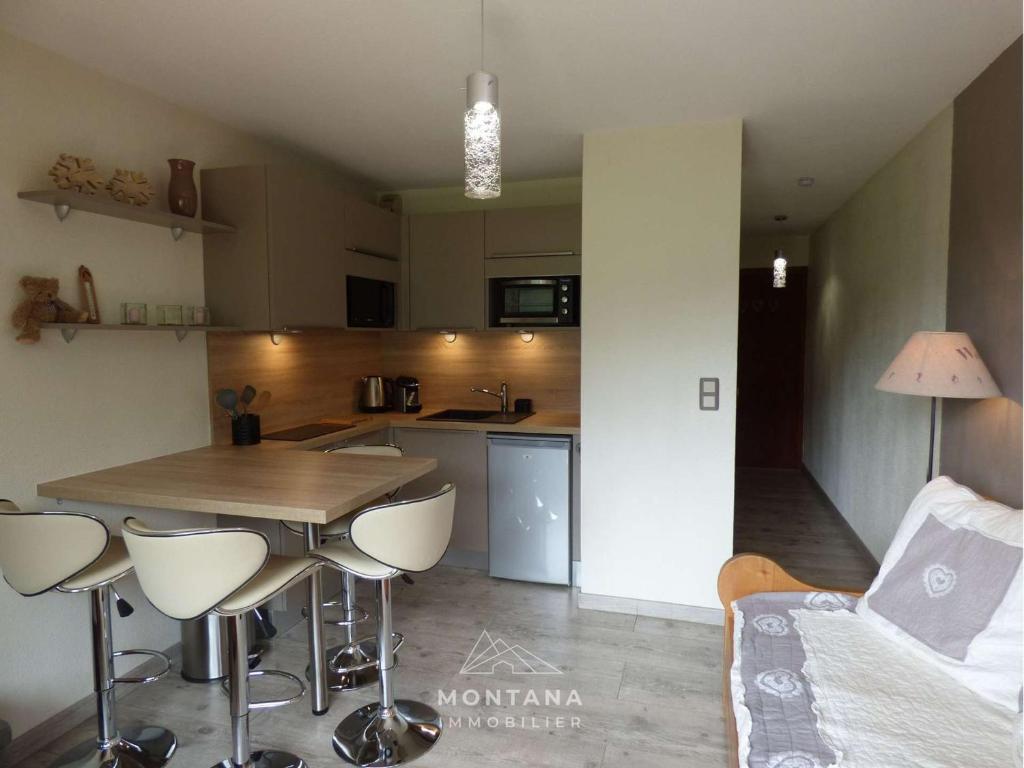 une cuisine et un salon avec une table et des chaises dans l'établissement Studio rénové 1er étage pour 4 pers. - Le Grand-Bornand - FR-1-458-182, au Grand-Bornand