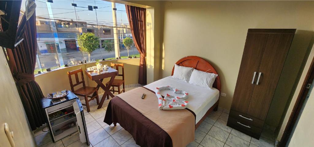 - une chambre avec un lit, une table et une fenêtre dans l'établissement Starlight Inn, à Pisco