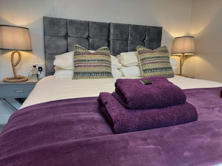 a bedroom with a large bed with a purple blanket at Potts House - Hornsea on the Yorkshire coast in Hornsea
