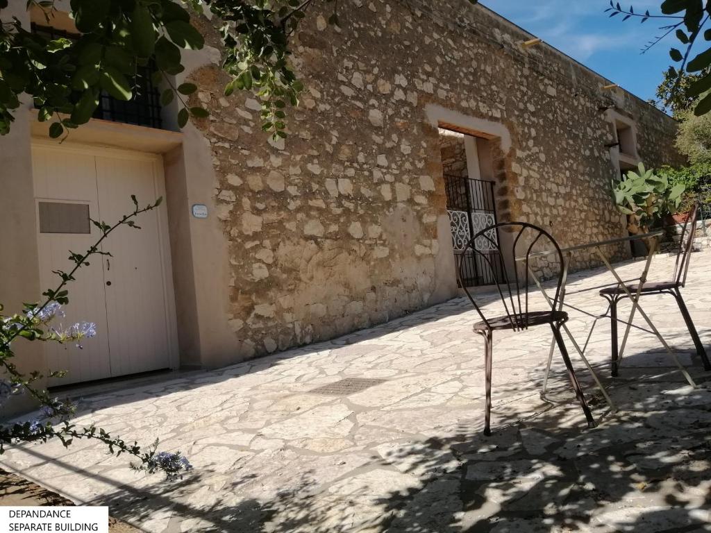 a pair of chairs sitting outside of a building at Tenute Plaia Agriturismo in Scopello