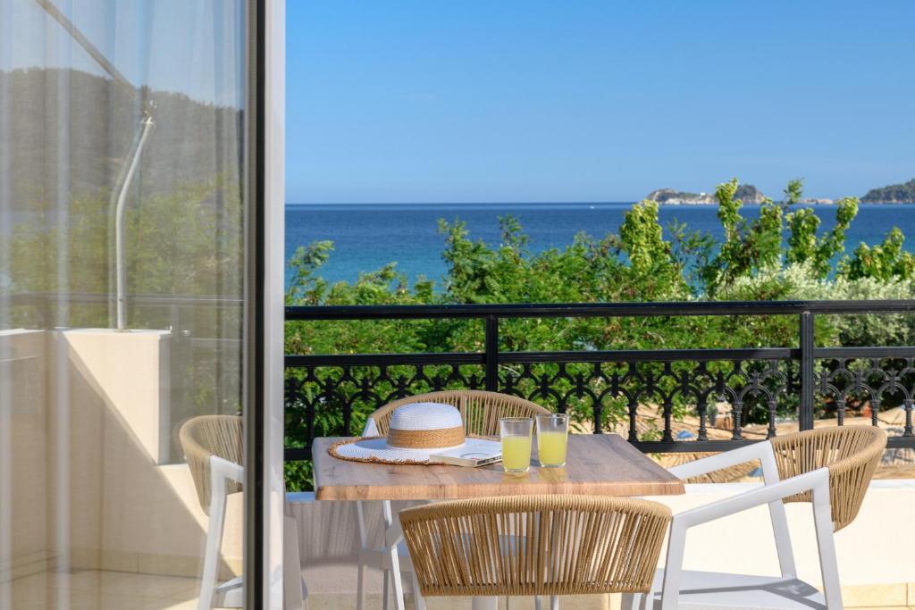 a table with a hat on a balcony with the ocean at Fotini Studios in Chrysi Ammoudia