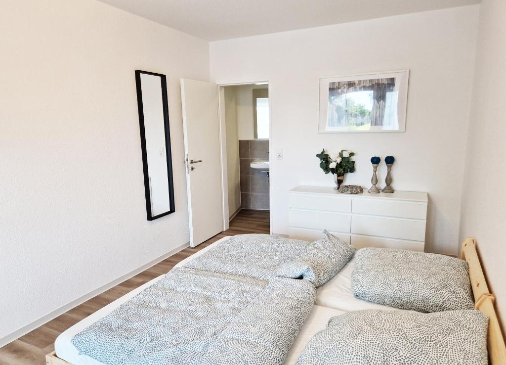 a bedroom with two beds and a mirror at Pension Weserufer in Brake