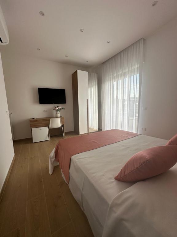 a bedroom with a bed and a flat screen tv at B&B Profumo di mare in Capaccio-Paestum