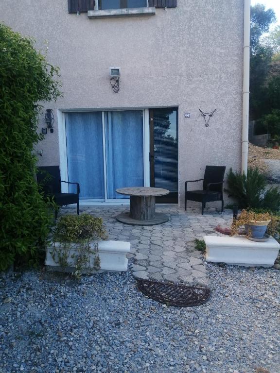 un patio avec une table et des chaises devant un bâtiment dans l'établissement studio meublé et équipé, à Bellegarde