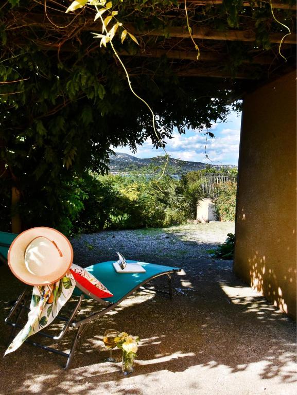 une planche de surf et un chapeau assis sur une plage dans l'établissement Piscine chauffée et magnifique vue mer! à10 mns de la plage & du centre!, à Cavalaire-sur-Mer