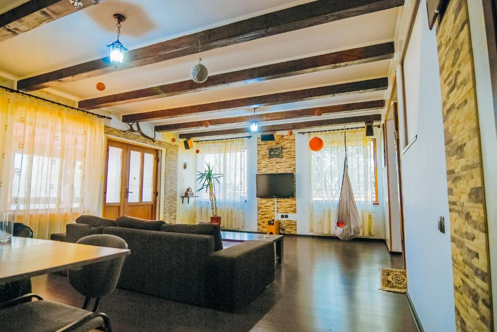 Una sala de estar con sofás y una mesa. en Retreat Drumul Vinului-Odobesti, en Boteşti