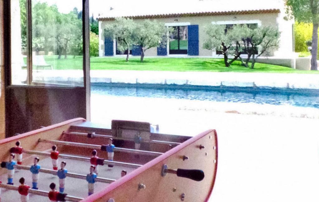 un grupo de figuritas de juguete al lado de una piscina en Le Mas Des Coquelicots, en Paradou