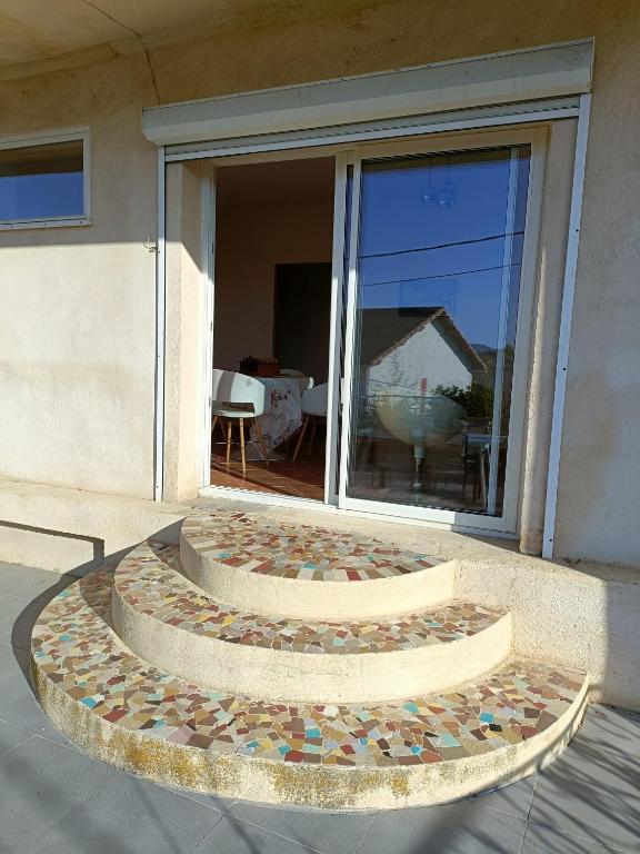 un banc en pierre devant un bâtiment avec une fenêtre dans l'établissement Maison individuelle vue sur le massif de l'étoile, à Marseille