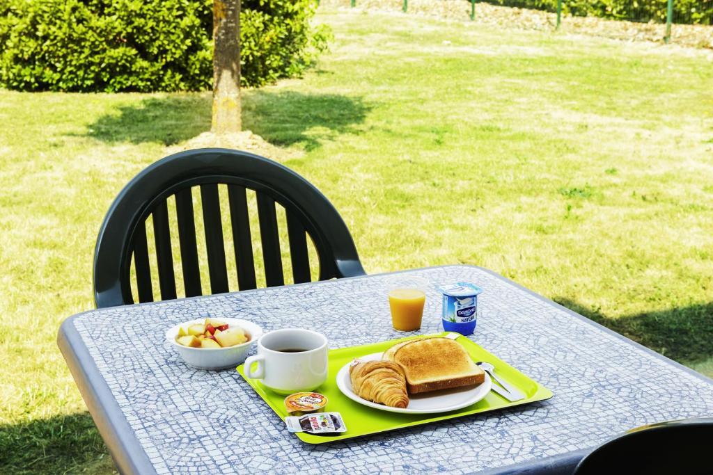a table with a plate of breakfast food on it at ibis budget Chartres in Chartres