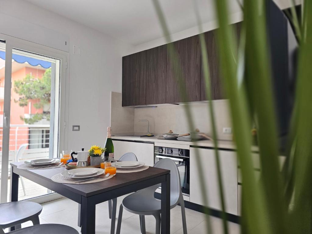 a kitchen with a table and chairs and a stove at Grey House 5 100mt dal mare in Tortoreto Lido