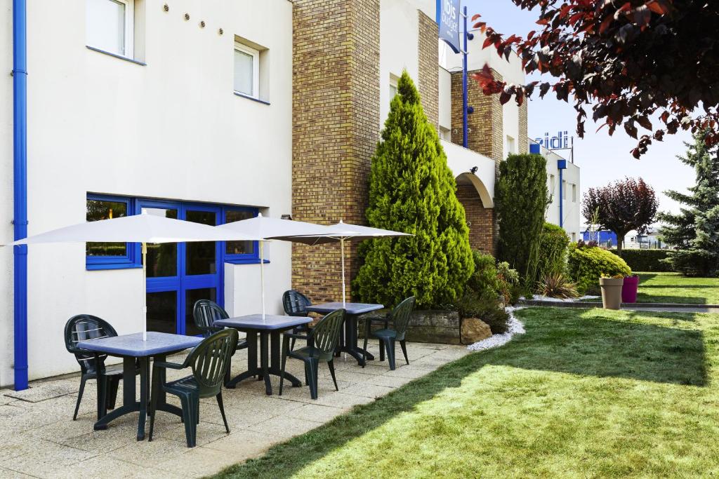 a patio with tables and chairs and umbrellas at ibis budget Chartres in Chartres