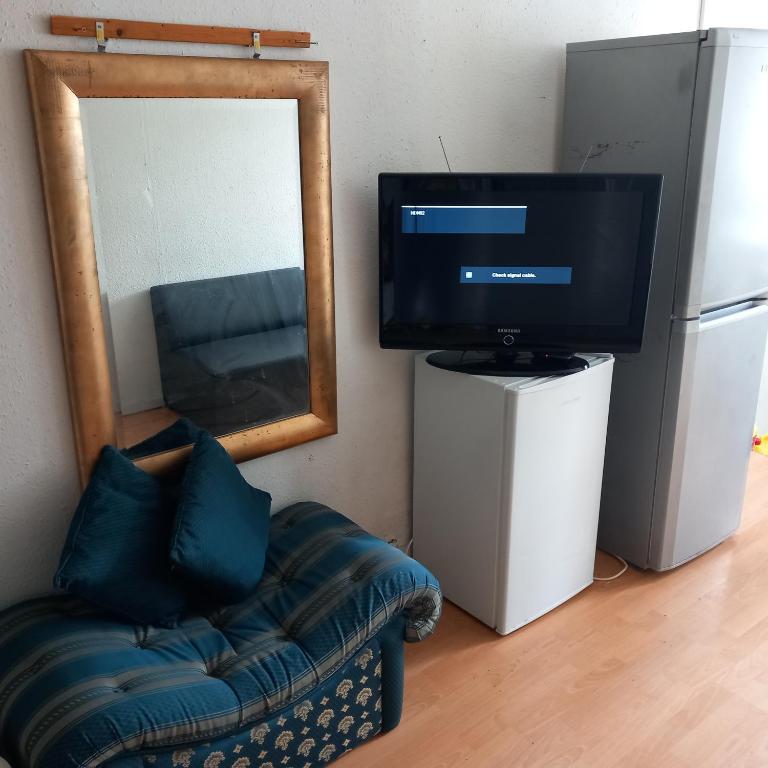 a living room with a couch and a television at Wara in Kingston upon Thames