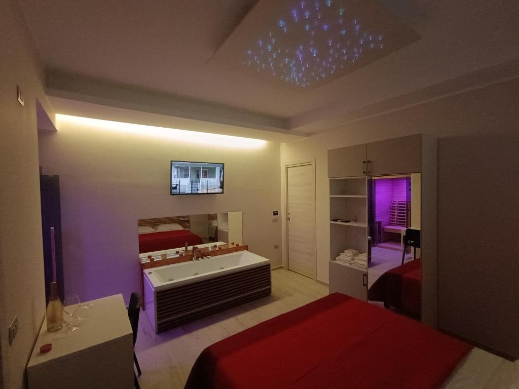 um quarto com uma cama, uma banheira e um espelho em I due piccioncini suite em Grottaminarda