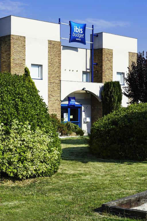 a building with a blue sign in front of it at ibis budget Chartres in Chartres