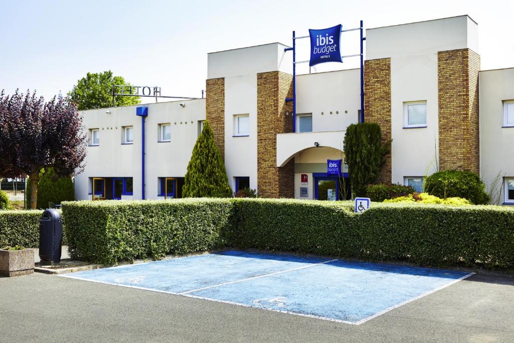 a building with a hedge in front of it at ibis budget Chartres in Chartres