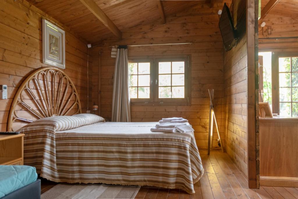 a bedroom with a bed in a wooden cabin at I Lecci Guesthouse in San Felice Circeo