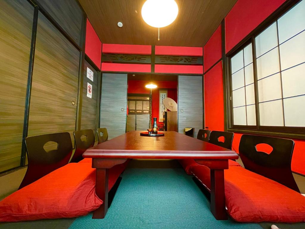 TRAVELERZ YOKOHAMA Demon Slayer House في Kikuna: غرفة طعام مع طاولة وكراسي خشبية