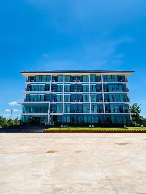 ein großes Gebäude mit blauen Fenstern davor in der Unterkunft Arunsakhon luxury condo in Ban Khok Kham