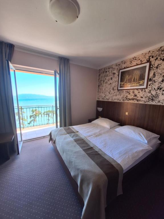 um quarto com uma cama grande e uma janela grande em VILLA VOLOSKO with private parking and breakfast,seaview em Volosko