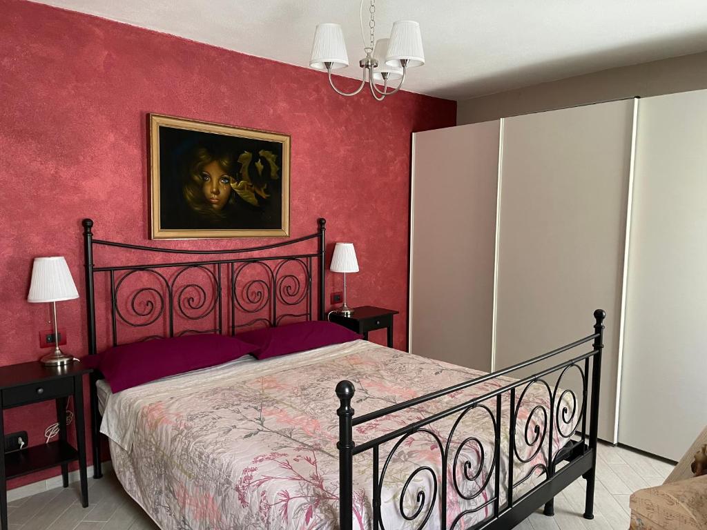a bedroom with a bed with a red wall at Casa vacanze Anais in Nus