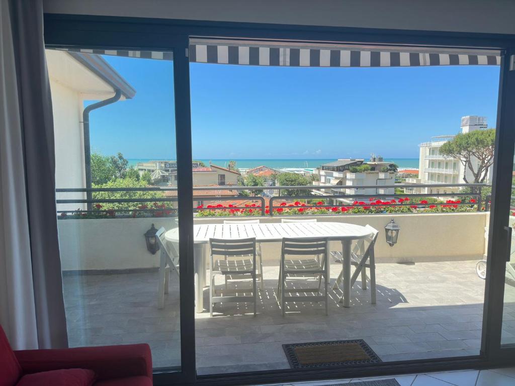 a view of a table and chairs on a balcony at Luxury Pentohuse near the Beach in Marina di Pietrasanta