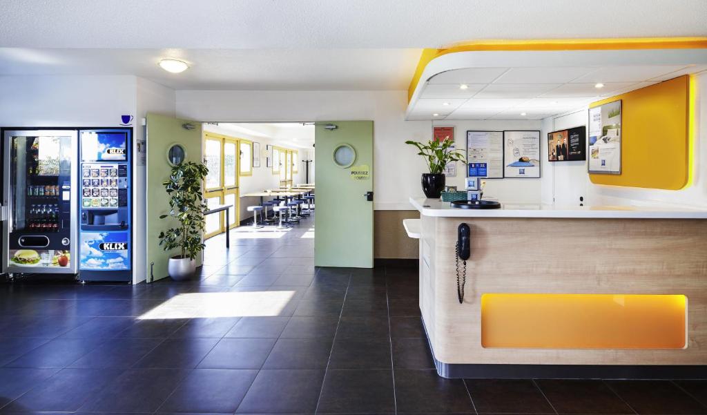 a restaurant with a counter in the middle of a room at ibis budget Chartres in Chartres
