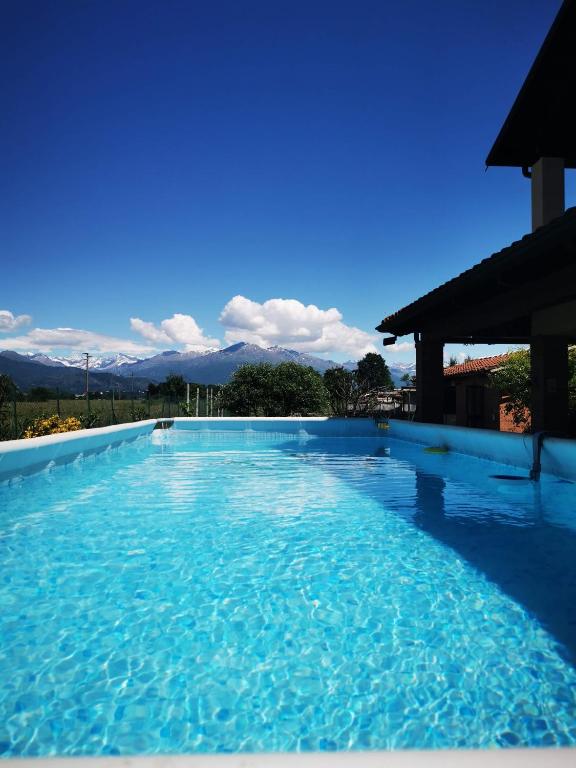 a swimming pool with blue water and mountains in the background at Orto del pettirosso Appartamento con piscina privata e BBQ in Front