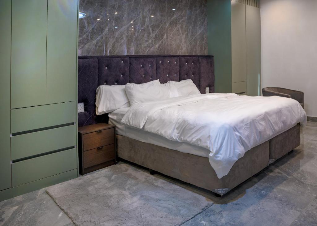 Un dormitorio con una cama grande con sábanas blancas. en FB-Canatal Luxury Apartments, en Ciudad del Cabo