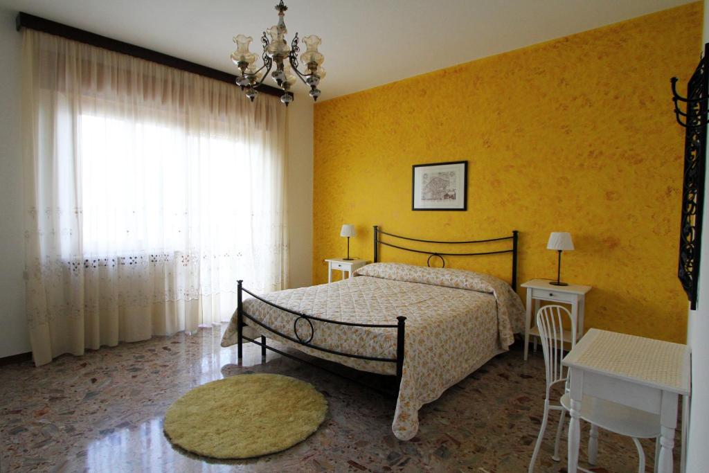 um quarto com uma cama e uma parede amarela em B&B L'Armonia em Fabriano