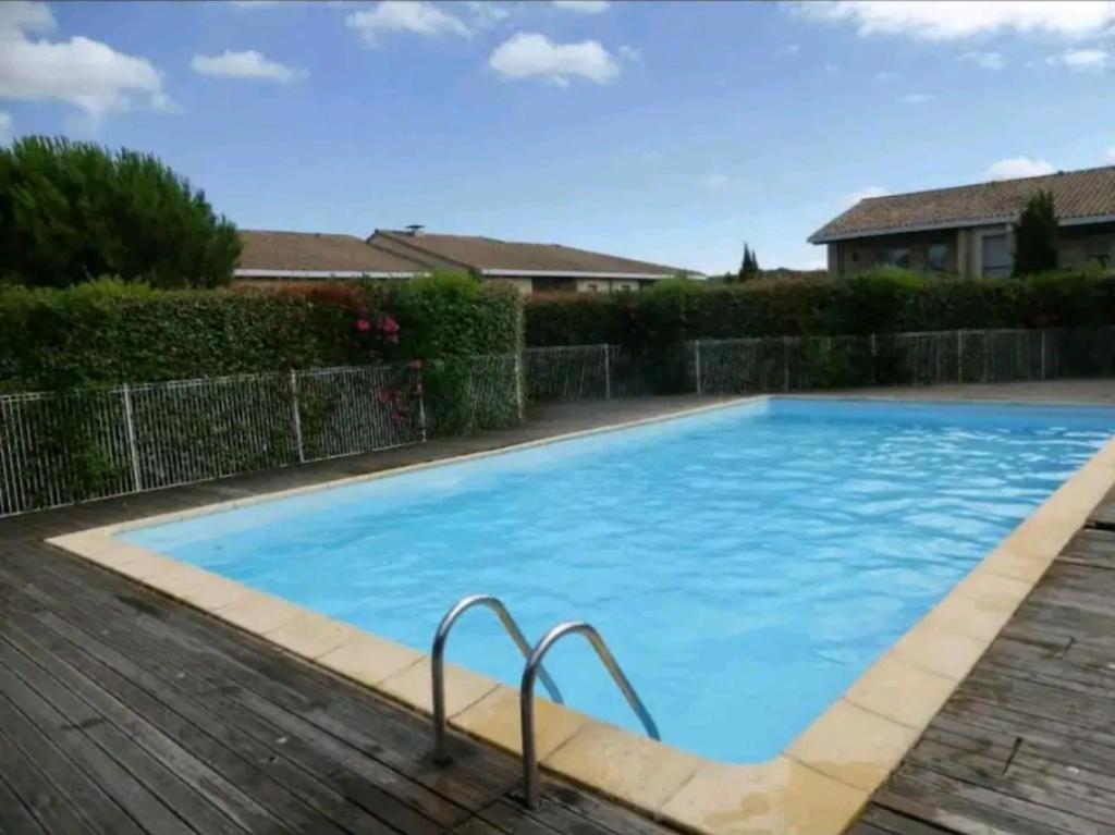 une grande piscine bleue sur une terrasse en bois dans l'établissement Bienvenue à Carcassonne, à Carcassonne