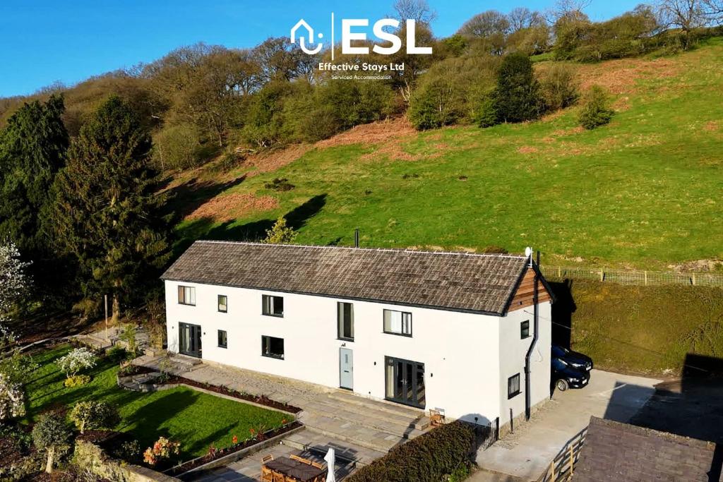 an aerial view of a white house on a hill at Large Country Farmhouse with Hot Tub and Shropshire Hills View in Minsterley