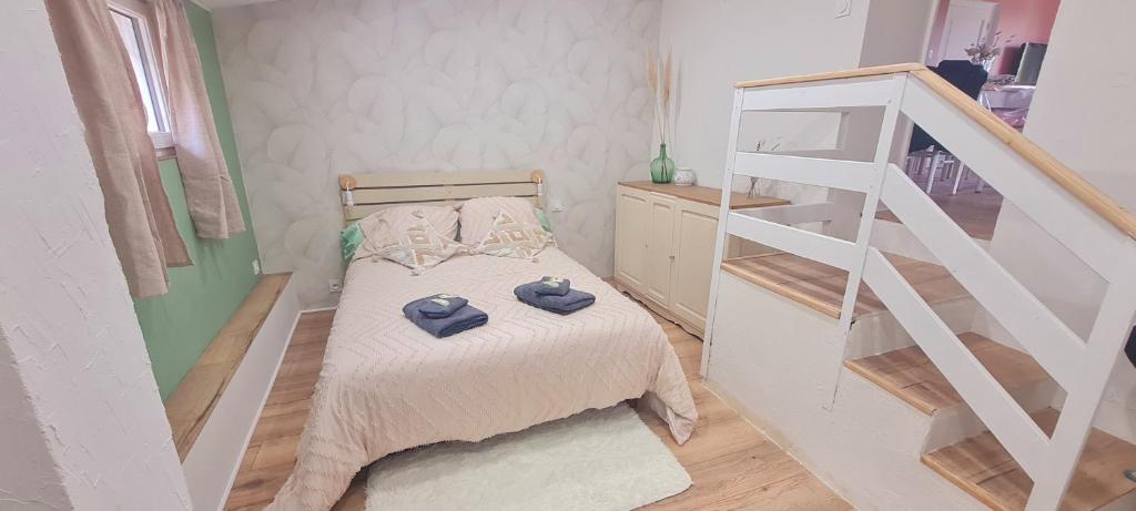 a small bedroom with a bed and a staircase at Maison campagne détente in Thorigné-sur-Dué