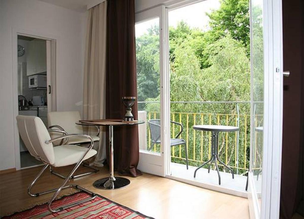 a room with a balcony with a table and chairs at Oase im Park in Berlin