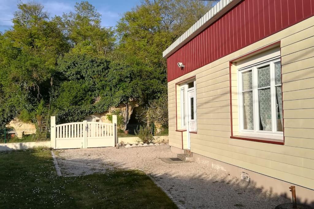ein Gebäude mit einem weißen Tor neben einem Haus in der Unterkunft Gîte au cœur des châteaux de la loire in Lignières-de-Touraine
