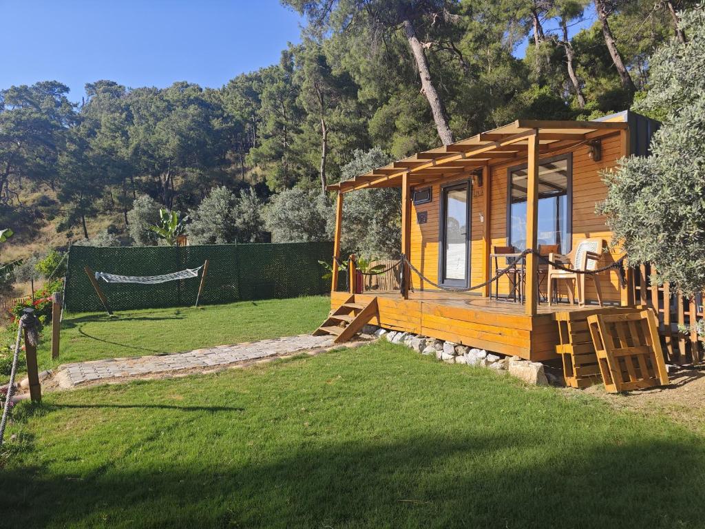 a small wooden cabin with a hammock in a yard at Tiny Mini House in Dalaman