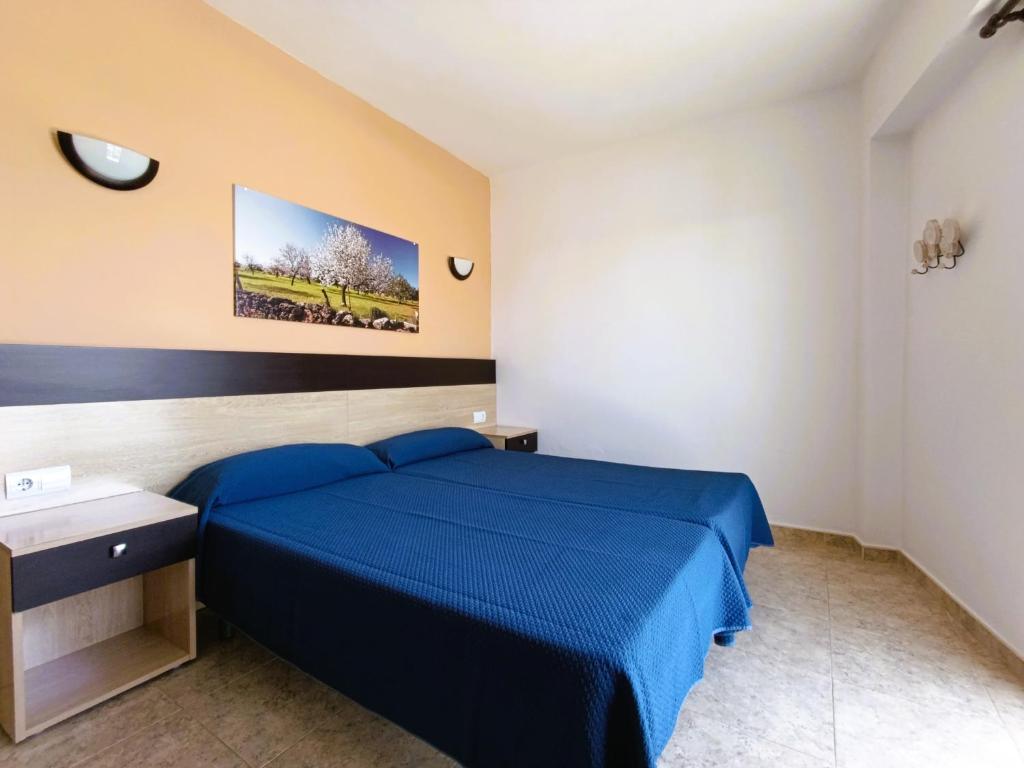 a bedroom with a blue bed in a room at Hostal Horizonte in San Antonio