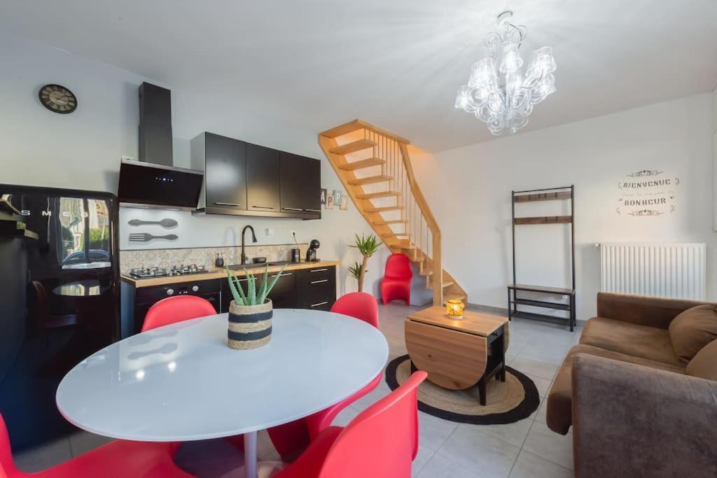 Il dispose d'une cuisine et d'un salon avec une table et des chaises rouges. dans l'établissement Maison , proximité Sovab, Batilly,Amnéville, Briey, à Joeuf