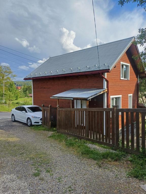 une maison avec une voiture garée devant elle dans l'établissement Карпатський котедж Karpatian cottage, à Vorokhta