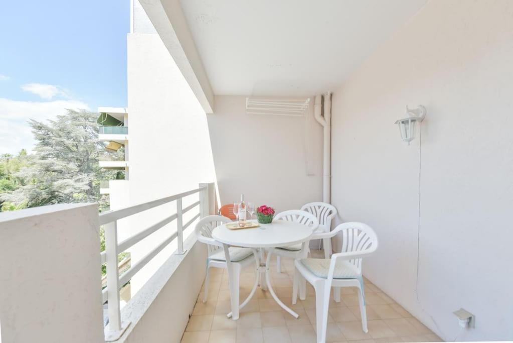 - un balcon blanc avec une table et des chaises blanches dans l'établissement PALM ROYAL - Apt for 4 with balcony - 5 minutes from the beach, à Antibes