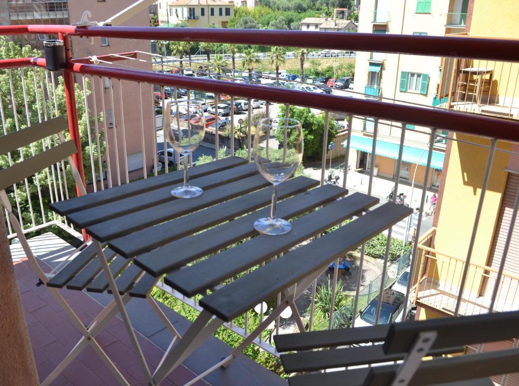 two wine glasses sitting on a table on a balcony at Dolce Hogar Residence in Chiavari