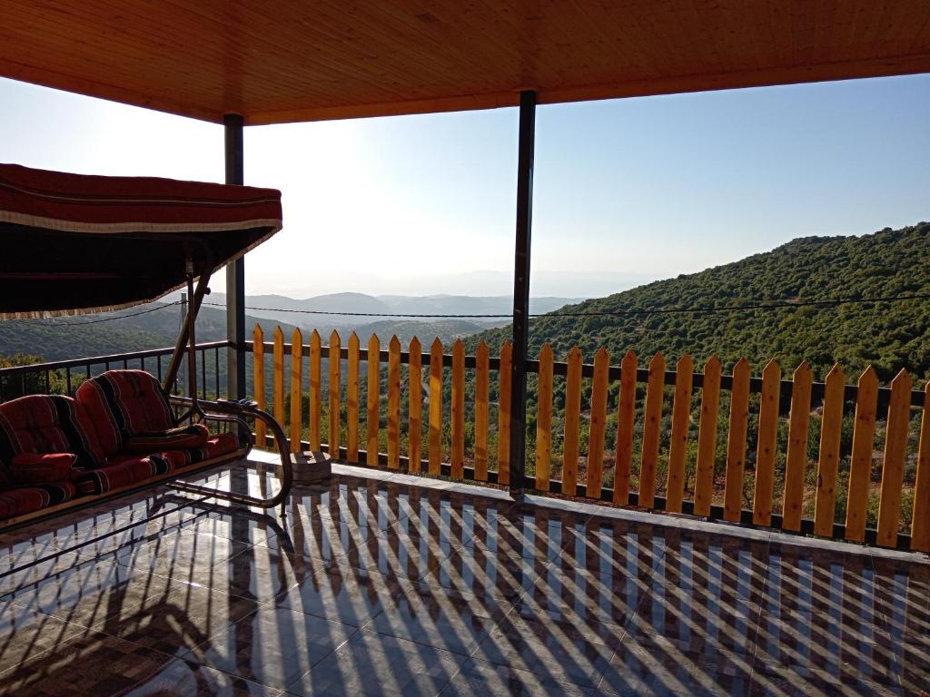 a porch with a chair and a view of the mountains at Mustafa Farm in Ajloun