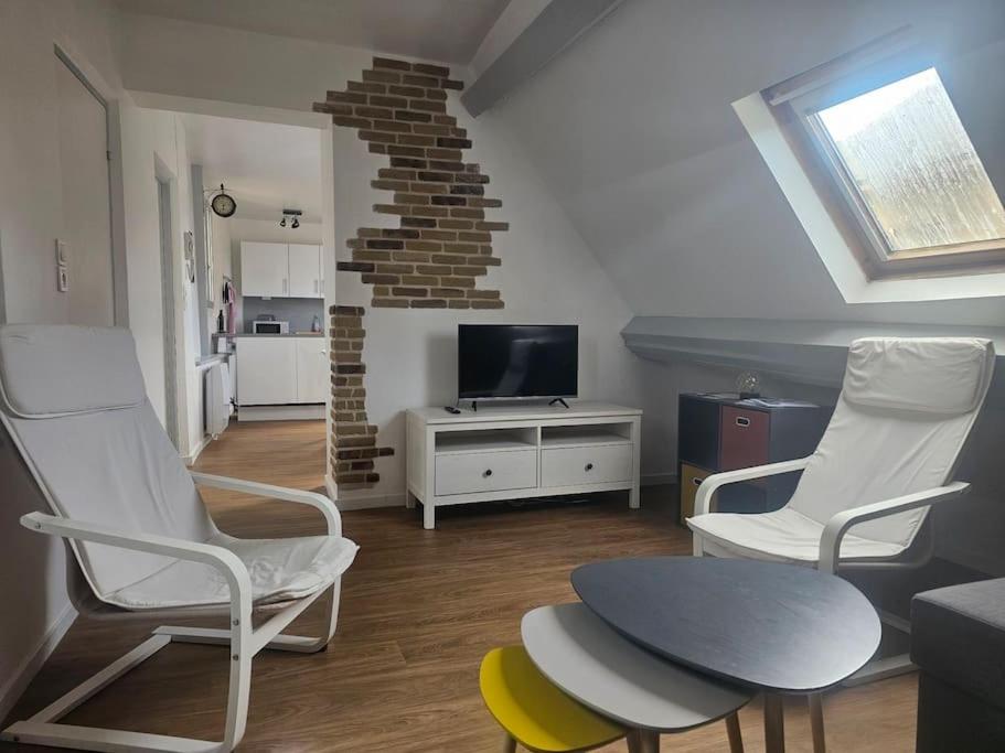 - un salon avec 2 chaises, une table et une télévision dans l'établissement Le Port Vauquelin, à Dieppe