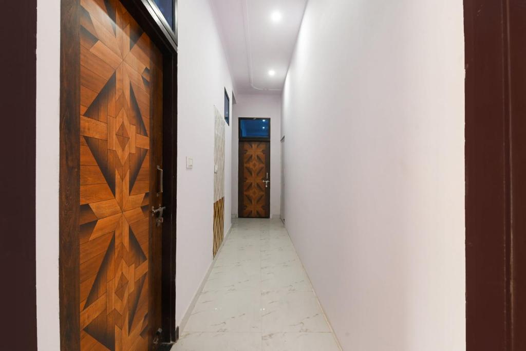 korytarz z dwoma drewnianymi drzwiami i korytarzem z białymi ścianami w obiekcie OYO Hotel Flight View w mieście Dżajpur