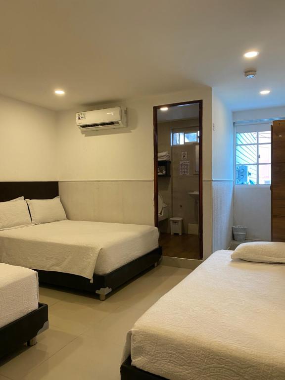 una camera d'albergo con due letti e un bagno di Apartahotel Marbella a San Andrés