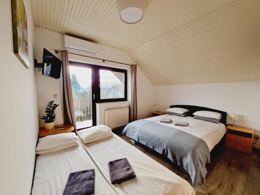 1 Schlafzimmer mit 2 Betten und einem Fenster in der Unterkunft Balaton Panzió Füred in Balatonfüred